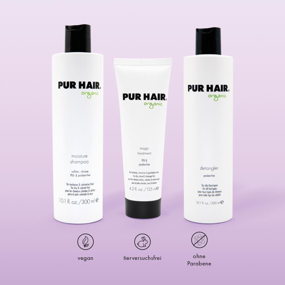 PUR HAIR Organic Haarpflege-Set: Moisture Shampoo, Magic Treatment und Detangler vor violetter Hintergrund. Symbole für vegan, tierversuchsfrei und ohne Parabene.