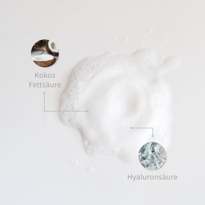 Weiße Schaum-Textur mit markierten Inhaltsstoffen: Kokosfettsäure, Hyaluronsäure